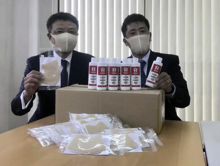 洗えるマスクと殺菌成分を含んだ美容液を寄贈したＩＮＡＣ神戸の安本卓史社長（右）とエムケイ西日本グループの青木義明社長（左）