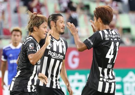 　前半１８分、先制ゴールを決め、チームメートと喜ぶ神戸・藤本憲明（左）