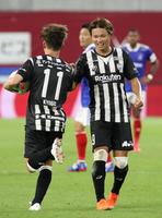 　試合終了間際、同点ゴールを決めた古橋亨梧（左）を笑顔で迎える神戸・藤本憲明