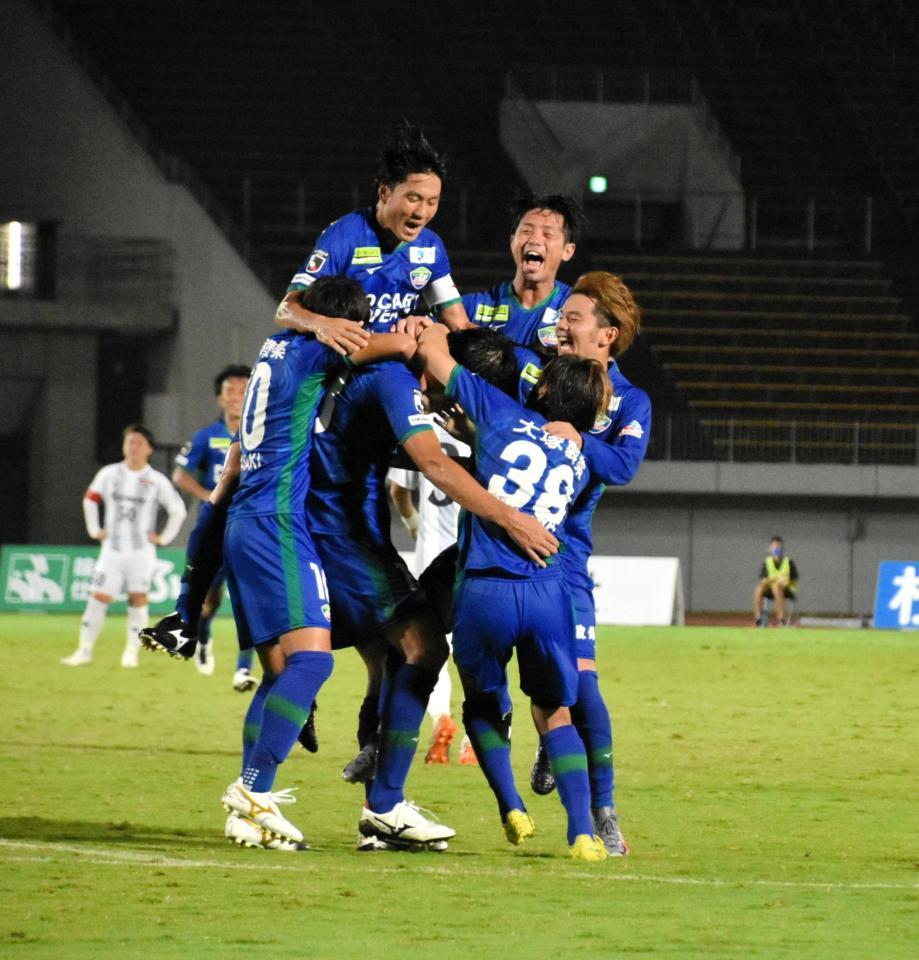 ゴールを決めチームメートの手荒い祝福を受ける佐藤（中央）