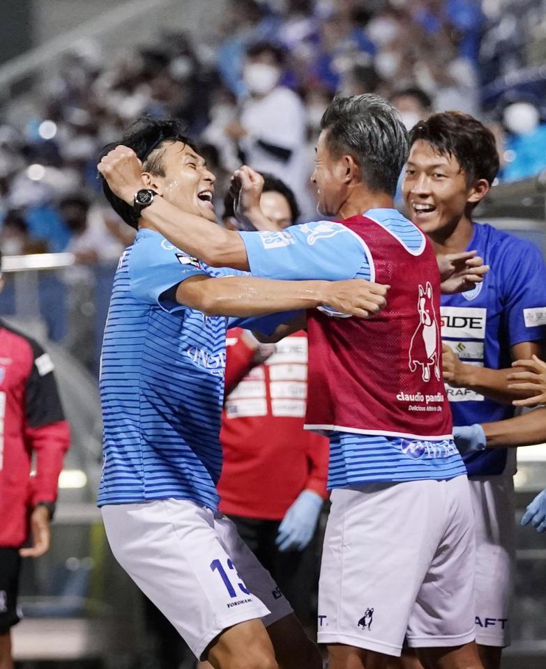 後半、決勝ゴールを決め、ベンチの三浦と抱き合う瀬沼（左）＝ニッパツ