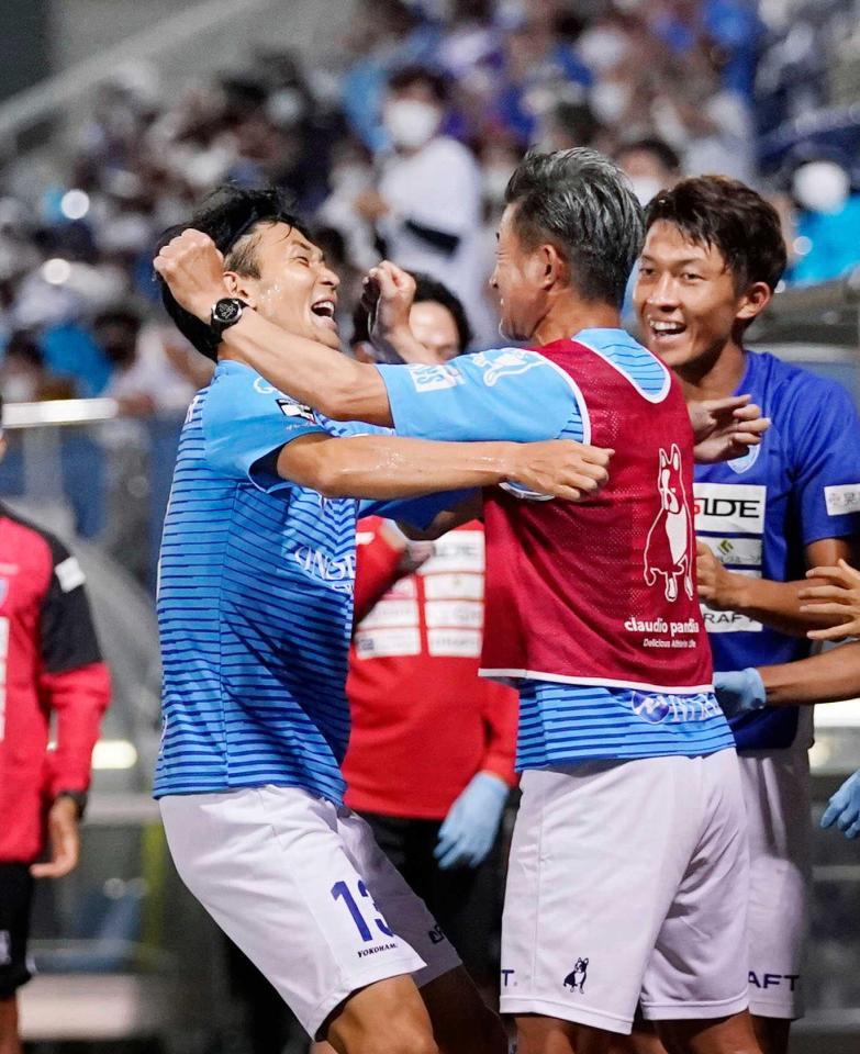 　後半、決勝ゴールを決め、ベンチの三浦と抱き合う瀬沼（左）