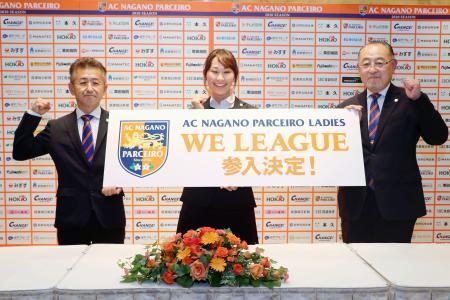　日本初のサッカー女子プロリーグ「ＷＥリーグ」への参入が決まり、写真に納まる長野の堀江三定会長（右）ら＝１５日、長野市