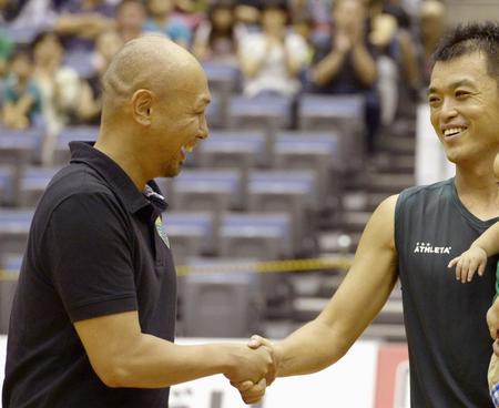 　１３年９月２２日、上咽頭がんの闘病から公式戦に復帰したフットサル神戸の鈴村拓也（右）と握手する久光重貴さん＝神戸総合運動公園体育館（提供・共同通信社）