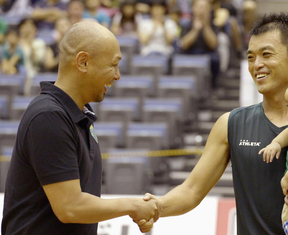 　１３年９月２２日、上咽頭がんの闘病から公式戦に復帰したフットサル神戸の鈴村拓也（右）と握手する久光重貴さん＝神戸総合運動公園体育館（提供・共同通信社）