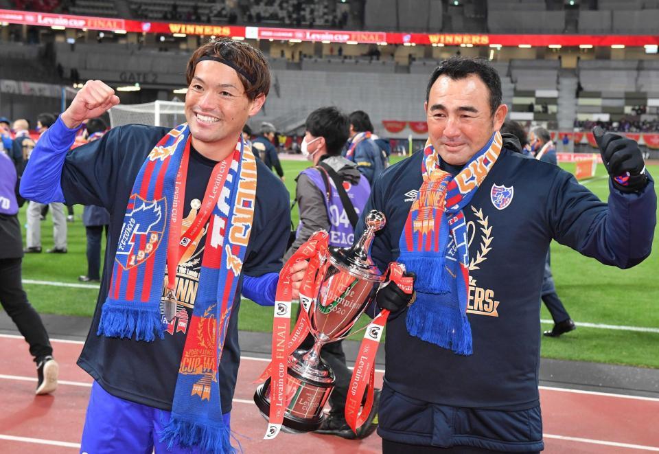 　優勝トロフィーを手にガッツポーズするＦＣ東京・東（左）と長谷川監督（撮影・高石航平）