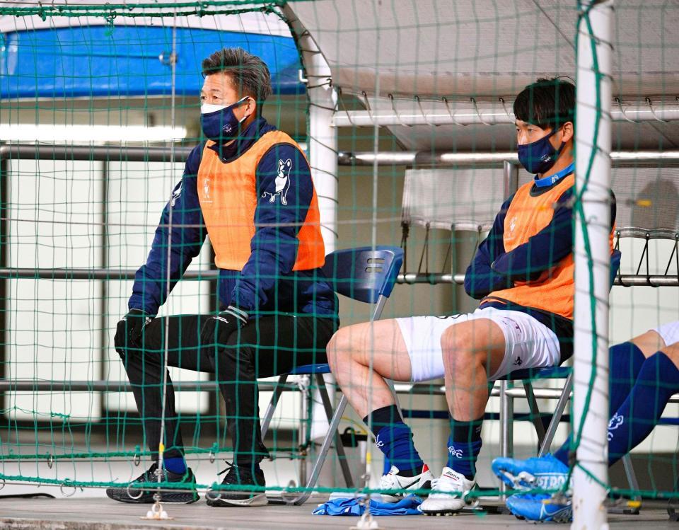 　前半、ベンチから試合を見守る横浜ＦＣ・三浦（左）