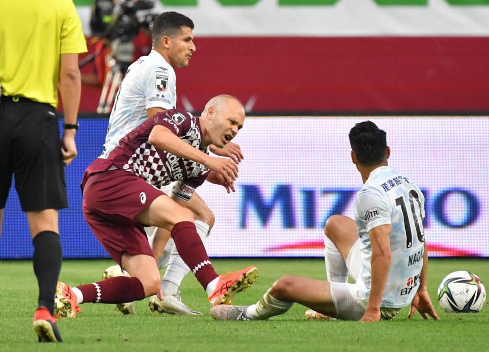 　前半、湘南・山田直輝（右）のタックルを受け、負傷交代となる神戸・イニエスタ（撮影・吉澤敬太）