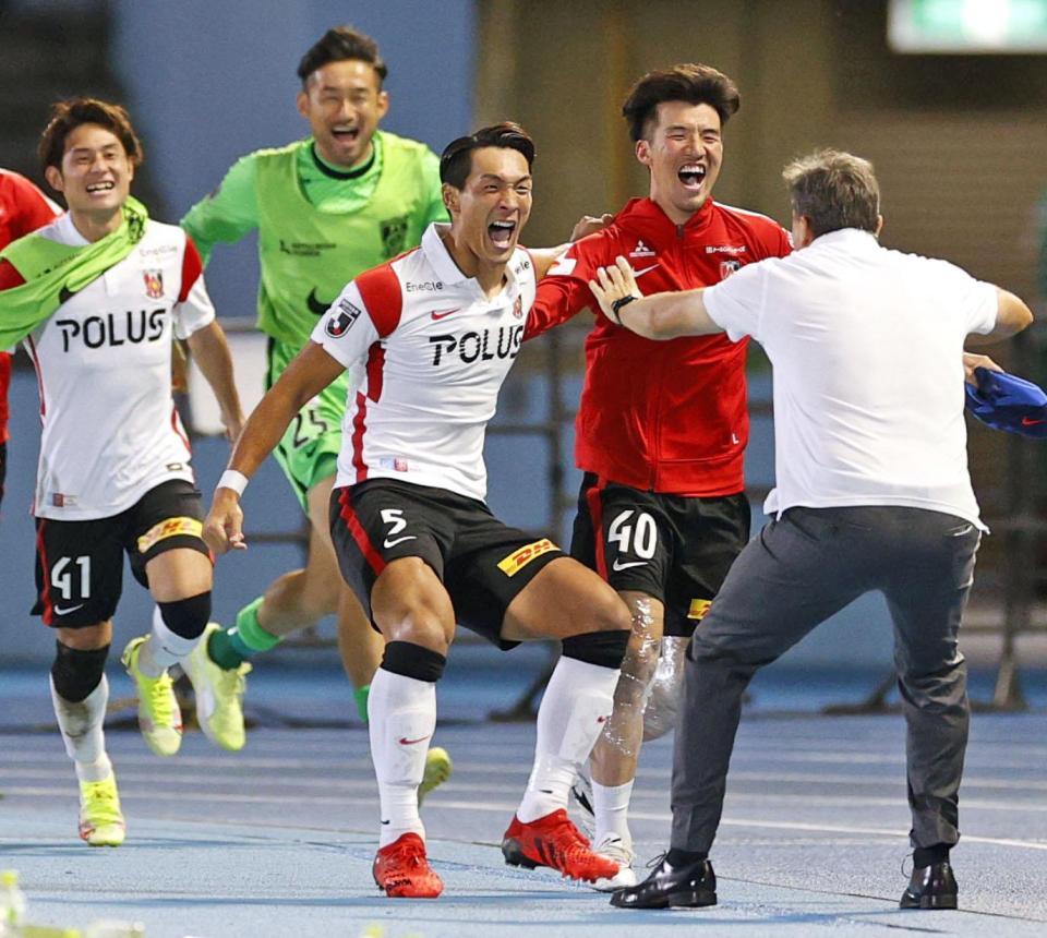 　試合終了間際、同点ゴールを決め、ロドリゲス監督の元に駆け寄る浦和・槙野（中央）＝等々力