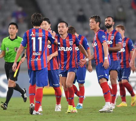 　横浜ＦＣに勝利し、イレブンとタッチを交わすＦＣ東京・長友（中央）＝撮影・西岡正