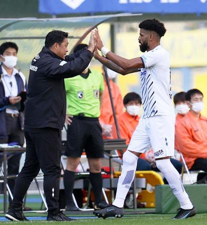 前半、同点ゴールを決め、松波監督（左）とタッチを交わすＧ大阪・パトリック＝昭和電ドーム