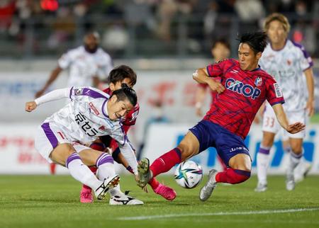 後半、シュートを放つ京都・宮吉（左）と岡山・井上