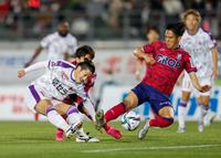 後半、シュートを放つ京都・宮吉（左）と岡山・井上