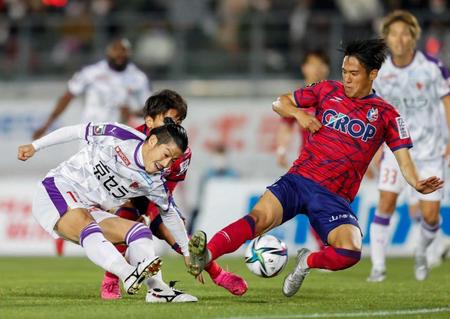 　後半、シュートを放つ京都・宮吉（左）と岡山・井上