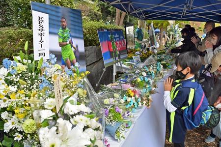 　急死した湘南のオリベイラ選手を悼み、献花台で手を合わせる人たち