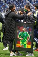 　Ｊ１残留が決定し、喜ぶ湘南の山口監督（左）。手前は急逝したオリベイラ選手の写真＝パナスタ