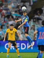 日本－オーストラリア　前半、空中で競り合う吉田（右）＝シドニー（共同）