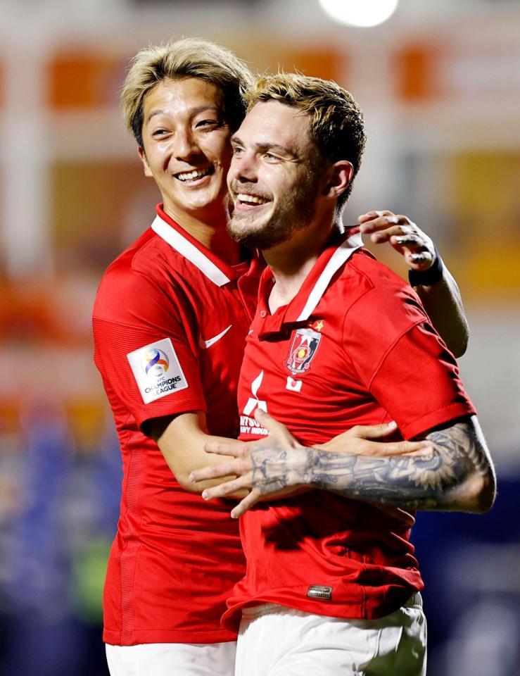 　後半、３点目のゴールを決めた浦和・モーベルグ（右）に笑顔で駆け寄る馬渡（共同）