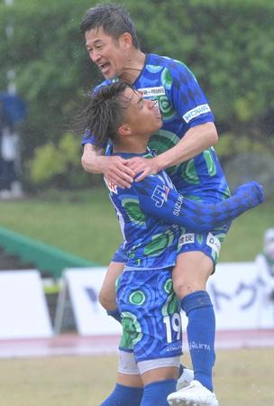 　後半、同点のゴールを決めた三宅海斗（左）を祝福する鈴鹿・三浦知良（撮影・高部洋祐）