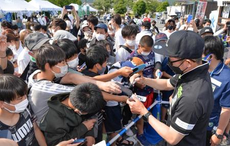 　試合後、集まった大勢のサポーターにサインして回るカズ