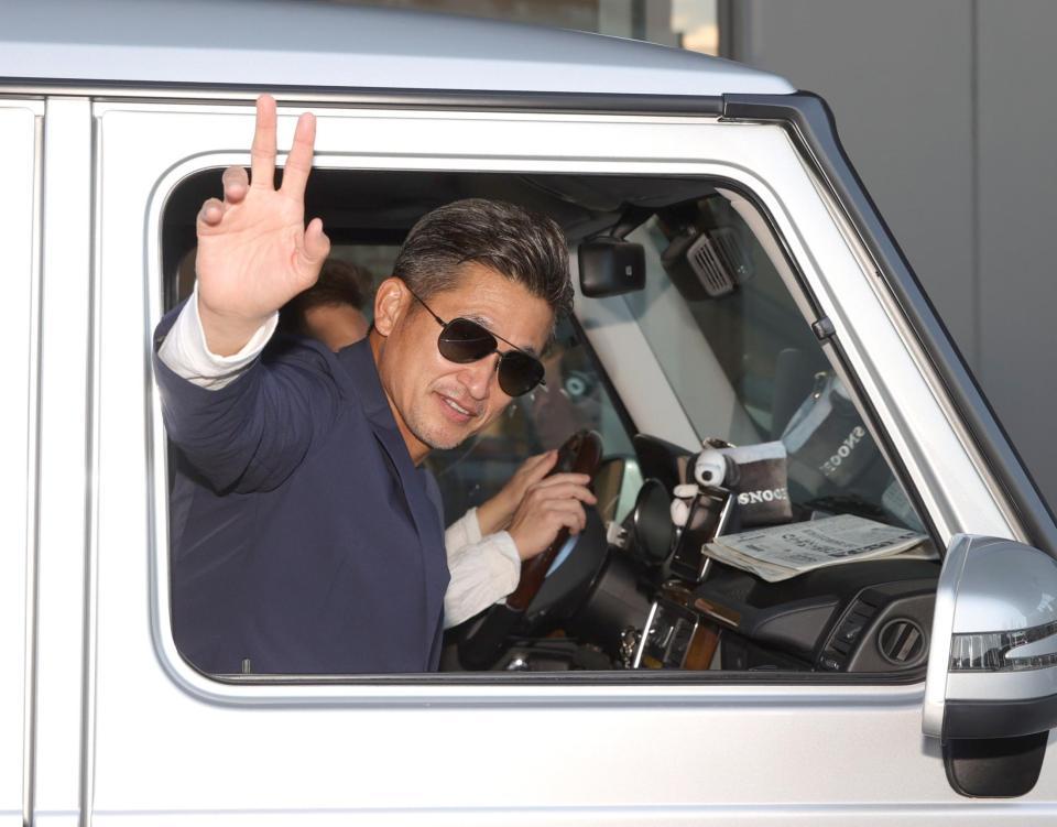 　駐車場の外に集まったファンに、車のウィンドーを下ろして手を振る三浦知良（撮影・坂部計介）