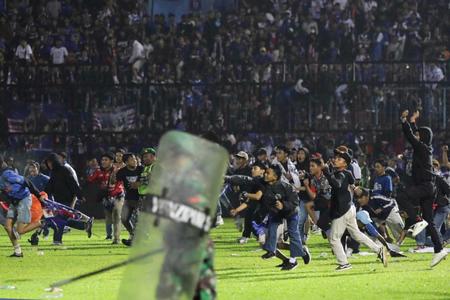 　１日、インドネシア東ジャワ州のサッカー場で、グラウンドに乱入する観客ら（ＡＰ＝共同）