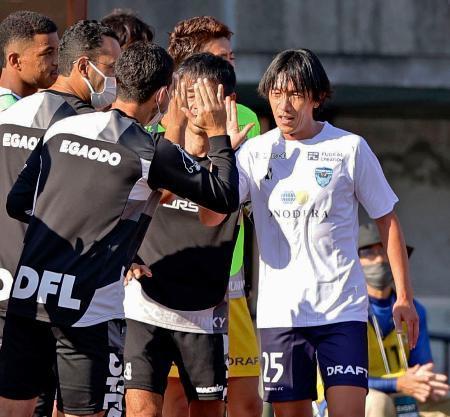 　Ｊ２熊本戦の後半途中に交代し、タッチを交わす横浜ＦＣの元日本代表ＭＦ中村俊輔（右）＝２３日、熊本市のえがお健康スタジアム