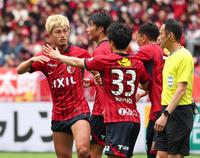 　前半、先制点を決め怒りの表情で木村博之主審（右端）に敬礼ポーズを見せる鹿島・鈴木優磨（左端）＝撮影・吉澤敬太