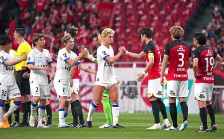 　引き分けに終わり、握手を交わす鹿島（左）と浦和の両イレブン
