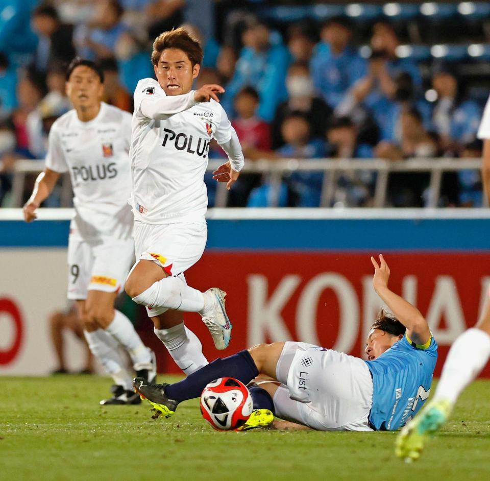 　後半、横浜ＦＣ・岩武（下）のディフェンスを突破する浦和・関根（中央）