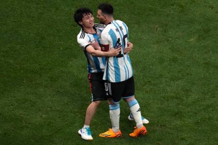 　中国北京市で１５日に開かれたサッカーの国際親善試合で、乱入した観客（左）に抱きつかれるアルゼンチン代表のメッシ選手（ＡＰ＝共同）