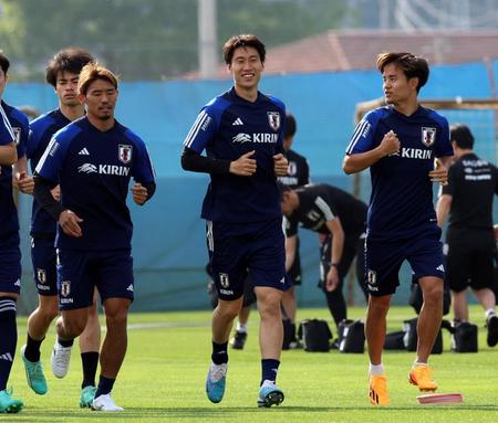 　笑顔を見せランニングする鎌田大地（中央）＝撮影・山口登