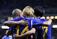 　後半、シュートを決めた伊東純也（中央）は前田大然（左）、三苫薫と肩を組む（撮影・中田匡峻）