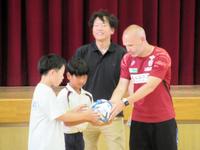 　児童にボールを贈呈するイニエスタ（右）