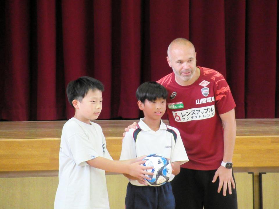 　児童にボールを贈呈するイニエスタ（右）