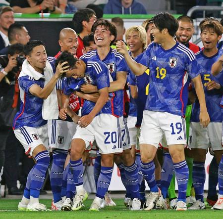 　試合終了間際、チーム４点目のゴールを決め、久保（手前左から２人目）を抱きしめて喜ぶ田中（共同）