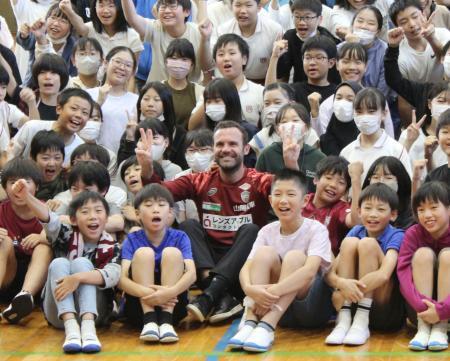 　神戸市内の小学校を訪れ、児童らと記念写真に納まるＪ１神戸のマタ（中央下）＝１２日