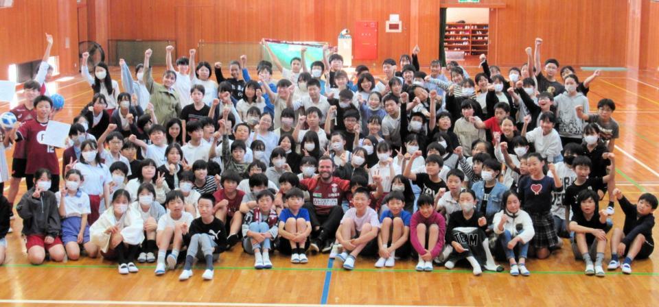 　児童らと写真撮影するマタ（中央）