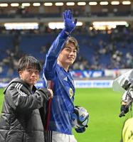 　ボールを抱えながらスタンドのファンに手を振る日本代表・上田綺世（右）。左は相馬勇紀＝１６日