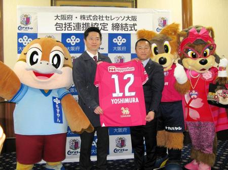 　Ｃ大阪・森島寛晃社長（右）からユニホームをプレゼントされた吉村洋文大阪府知事