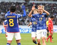後半、ゴールを決めた南野拓実（左）と笑顔でタッチする中村敬斗＝国立競技場（撮影・棚橋慶太）