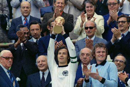 　１９７４年７月、サッカーＷ杯西ドイツ大会で優勝し、トロフィーを掲げるベッケンバウアー（中央）＝ミュンヘン（ＡＰ＝共同）