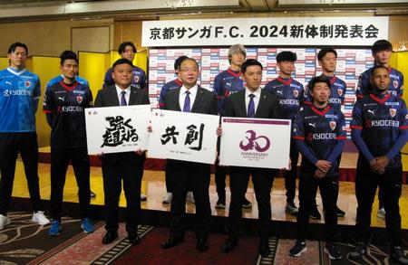 　京都の新スローガンと30周年ロゴを発表した曹貴裁監督（左から３人目）、伊藤雅章社長（中央）、安藤淳強化部長（前列右から３人目）と新加入選手