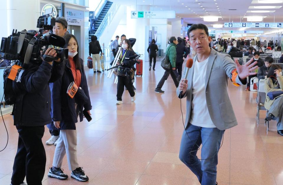 　サッカーの北朝鮮代表到着に備える空港の様子をリポートする中山正敏リポーターら（撮影・吉澤敬太）