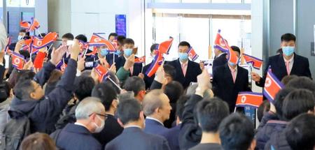 　国旗を持った大勢の人たちに出迎えられ、来日したサッカー北朝鮮代表の選手たち（撮影・吉澤敬太）