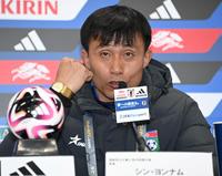 　試合後の会見で、質問に対し握りこぶしを作り語気を強め話す北朝鮮代表・シン・ヨンナム監督＝３月２１日