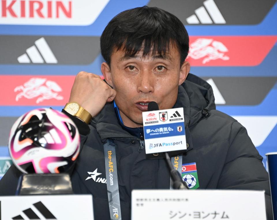 　試合後の会見で、質問に対し握りこぶしを作り語気を強め話す北朝鮮代表・シン・ヨンナム監督＝３月２１日