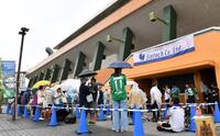 　雨が降る中、会場を待つサポーター（撮影・中田匡峻）