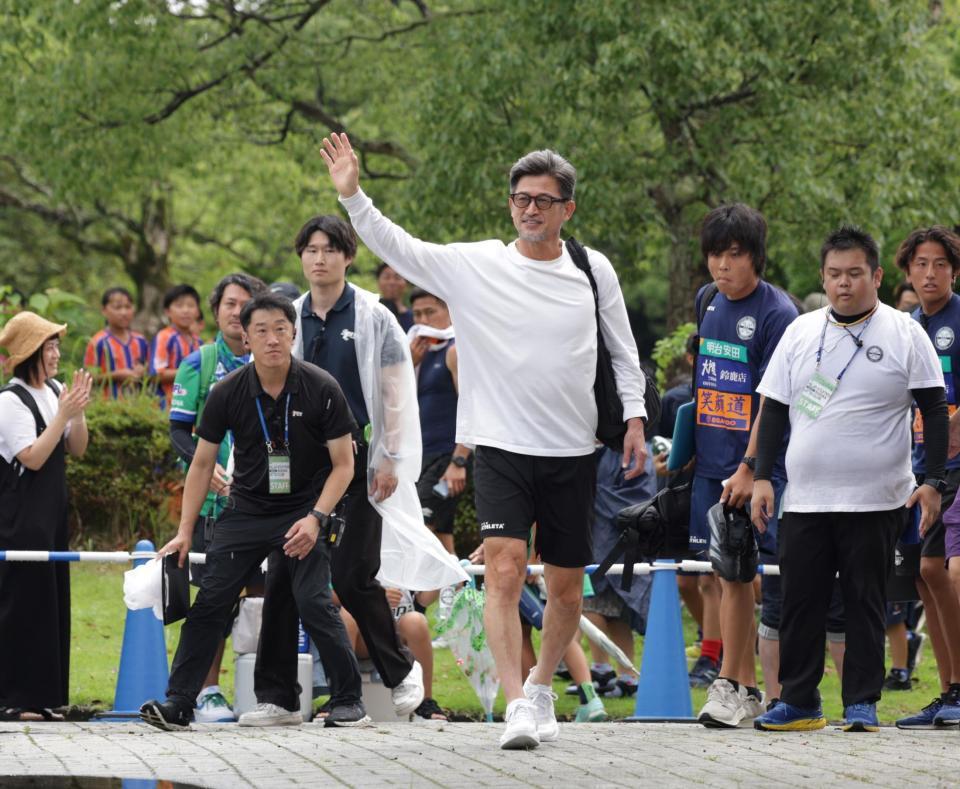 　スタジアムに向かって歩きながら、サポーターに手を振る三浦（撮影・中田匡峻）