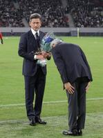 　明治安田・永島英器社長から花束を受け取る鈴鹿・三浦知良（撮影・金田祐二）